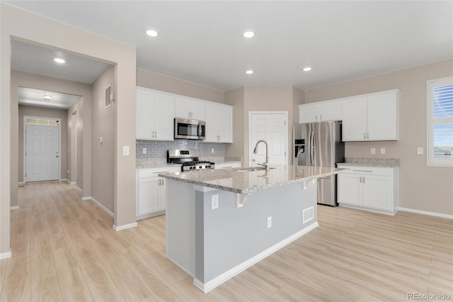 15525 Quince Cir, Thornton, CO 80602 - kitchen with stainless steel appliances, a sink, light wood-style flooring, baseboards, and recessed lighting