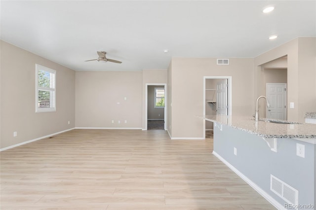 15525 Quince Cir, Thornton, CO 80602 - unfurnished living room featuring ceiling fan, a sink, light wood-type flooring, baseboards, and recessed lighting