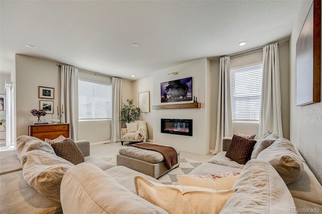 10499 Rolling Peaks Dr, Peyton, CO 80831 - carpeted living area featuring a glass covered fireplace, plenty of natural light, and recessed lighting