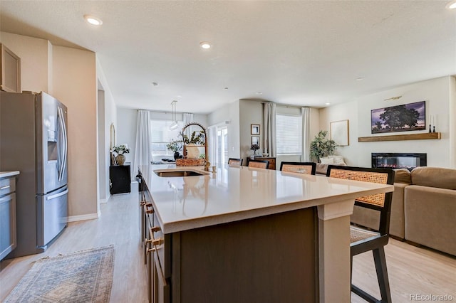 10499 Rolling Peaks Dr, Peyton, CO 80831 - kitchen featuring stainless steel fridge, light wood finished floors, plenty of natural light, open floor plan, and recessed lighting