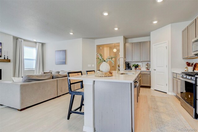 10499 Rolling Peaks Dr, Peyton, CO 80831 - kitchen featuring appliances with stainless steel finishes, a sink, a kitchen breakfast bar, open floor plan, and an island with sink