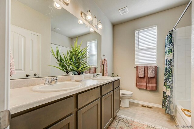 10499 Rolling Peaks Dr, Peyton, CO 80831 - bathroom with healthy amount of natural light, toilet, double vanity, and wood finished floors