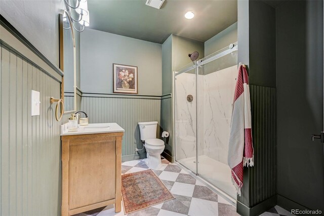10499 Rolling Peaks Dr, Peyton, CO 80831 - bathroom featuring a marble finish shower, toilet, vanity, and a wainscoted wall