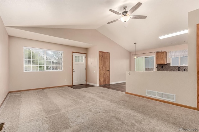 4318 Suncreek Dr, Loveland, CO 80538 - unfurnished living room featuring a ceiling fan, visible vents, vaulted ceiling, carpet floors, and baseboards
