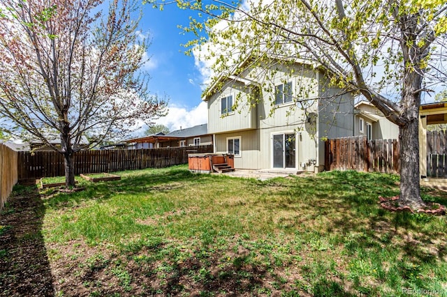 4318 Suncreek Dr, Loveland, CO 80538 - rear view of house with a fenced backyard, a lawn, and a hot tub
