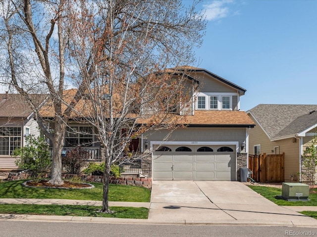 view of front of house with roof with shingles, a garage, fence, a front lawn, and concrete driveway