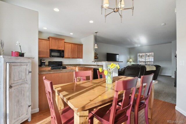 dining space featuring a chandelier, hardwood / wood-style floors, and sink