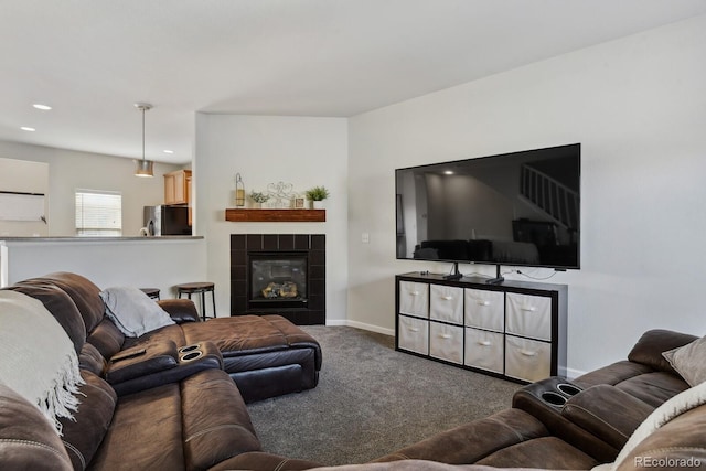 living room featuring a tile fireplace and carpet flooring