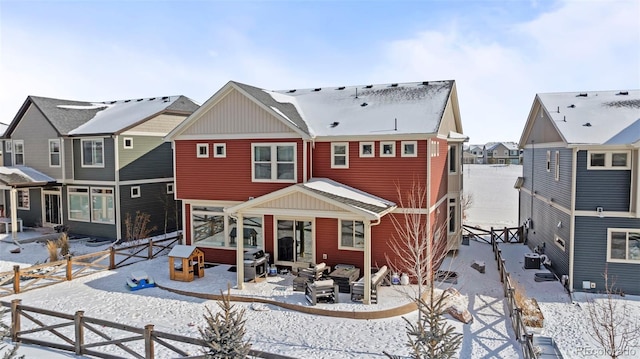 snow covered house featuring central AC