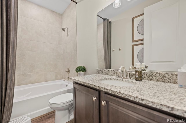 full bathroom featuring toilet, tiled shower / bath combo, hardwood / wood-style flooring, and vanity