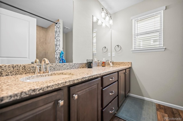 bathroom featuring wood-type flooring, walk in shower, and vanity