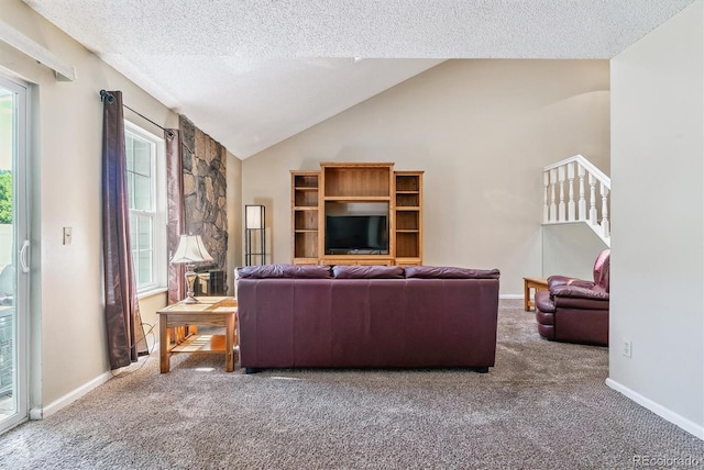 living room with a textured ceiling, carpet flooring, high vaulted ceiling, and a healthy amount of sunlight