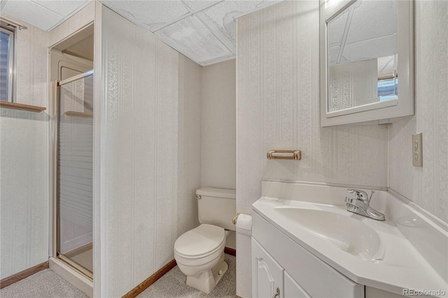bathroom featuring toilet, a stall shower, vanity, and baseboards