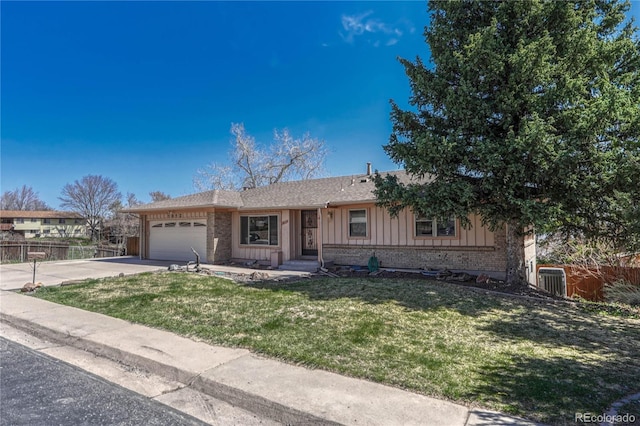 ranch-style home featuring concrete driveway, a front yard, board and batten siding, and fence