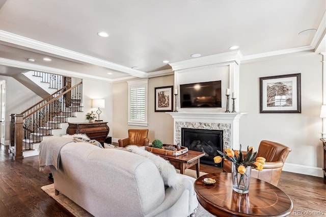 living room with a high end fireplace, dark wood-type flooring, and ornamental molding