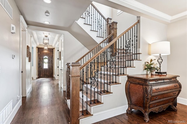 foyer featuring dark wood-type flooring and ornamental molding