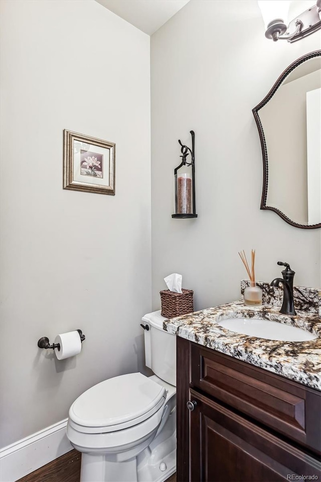 bathroom with vanity, hardwood / wood-style floors, and toilet