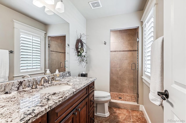 bathroom with walk in shower, vanity, and toilet