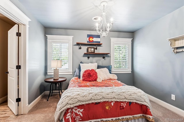 carpeted bedroom with multiple windows and a notable chandelier