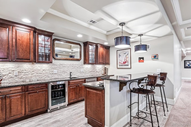 kitchen featuring sink, a kitchen island, dark stone counters, beverage cooler, and backsplash