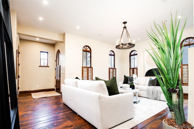 living room with dark wood-type flooring and a notable chandelier