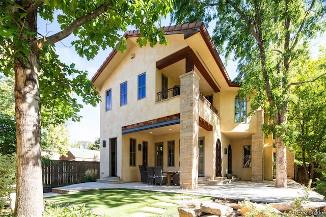 2435 S Milwaukee St, Denver, CO 80210 - rear view of house with stucco siding, a balcony, a patio area, and a tiled roof