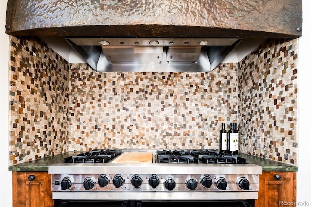 2435 S Milwaukee St, Denver, CO 80210 - kitchen with stainless steel stove, backsplash, brown cabinets, ventilation hood, and dark countertops