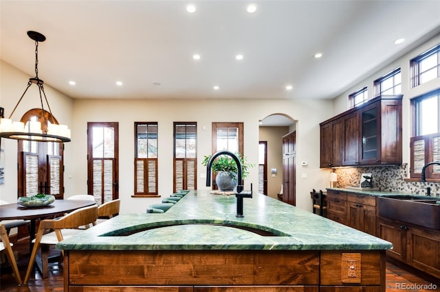 2435 S Milwaukee St, Denver, CO 80210 - kitchen with a sink, an island with sink, recessed lighting, tasteful backsplash, and hanging light fixtures