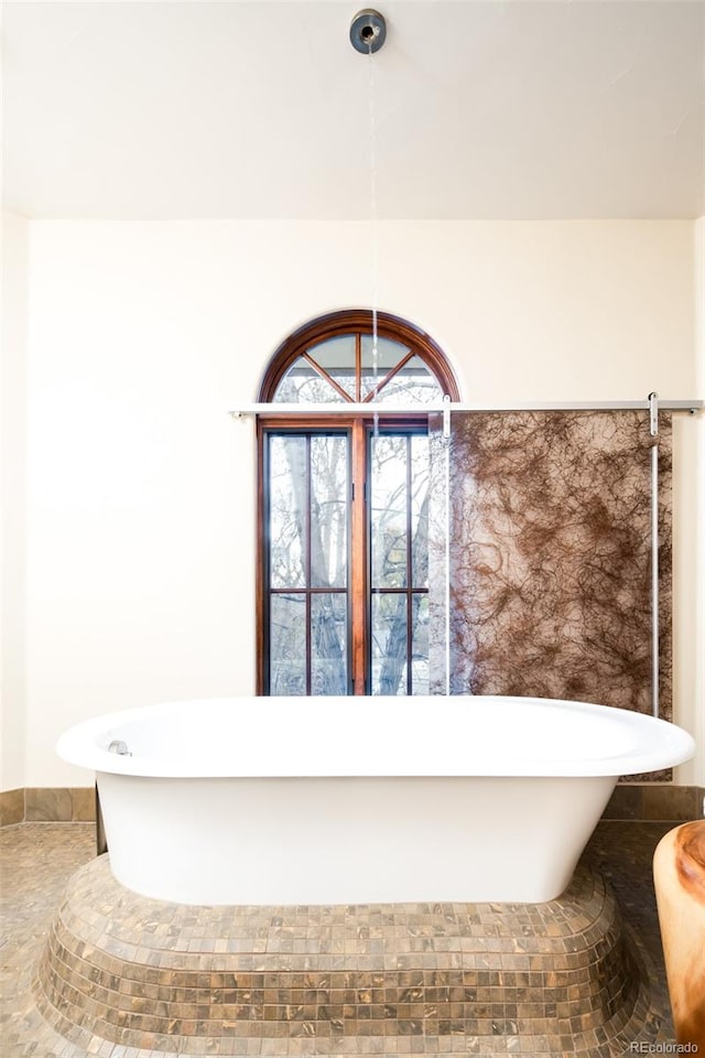 bathroom with a bathtub and tile patterned flooring