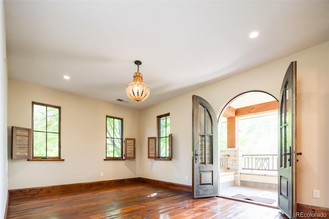 empty room featuring dark hardwood / wood-style floors and a notable chandelier