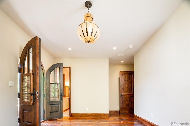 unfurnished room with a chandelier and hardwood / wood-style flooring