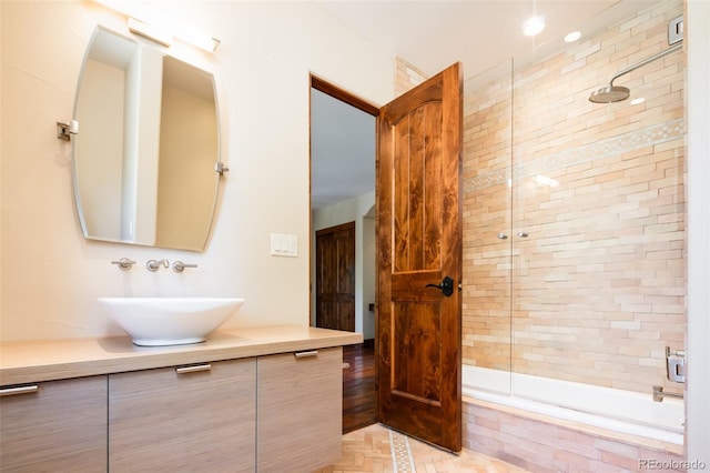 bathroom featuring tiled shower / bath combo and vanity