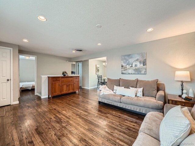 living room featuring a textured ceiling and dark hardwood / wood-style floors