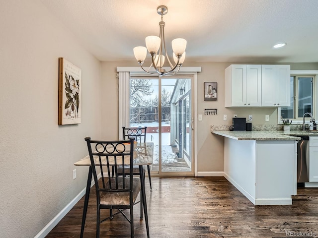 kitchen with light stone countertops, white cabinets, decorative light fixtures, and a notable chandelier