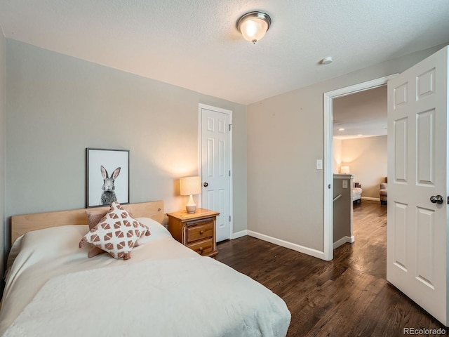 bedroom featuring a textured ceiling and dark hardwood / wood-style floors