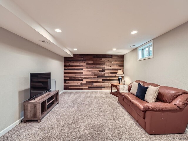 carpeted living room featuring wooden walls