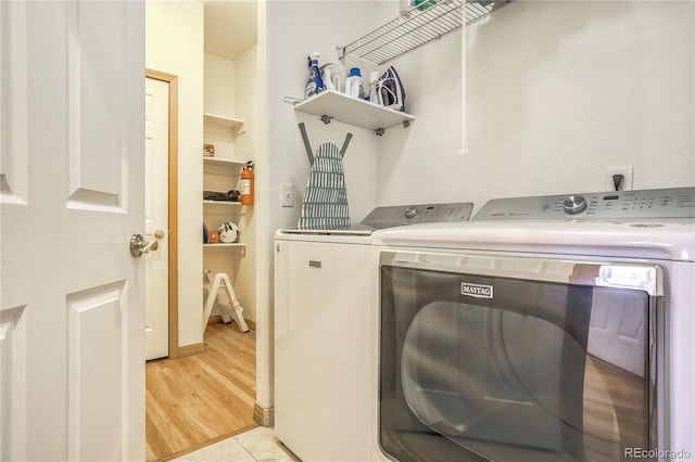 laundry room with light hardwood / wood-style flooring and washer and dryer