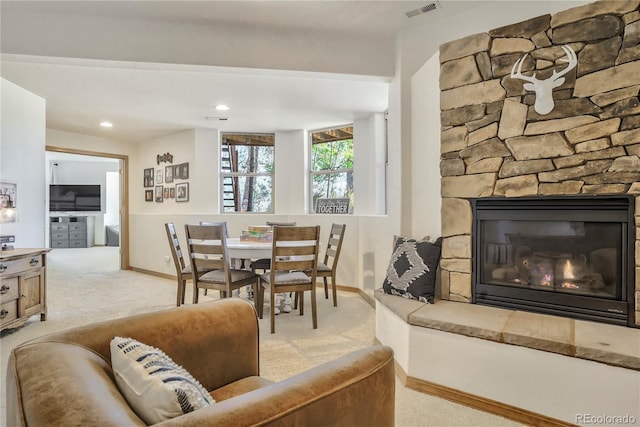 dining area featuring a fireplace and light carpet