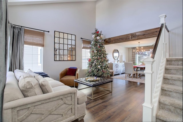 living room featuring a wealth of natural light, beamed ceiling, a chandelier, and dark hardwood / wood-style floors