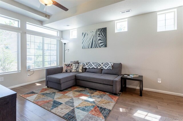 living room with ceiling fan, wood-type flooring, and plenty of natural light