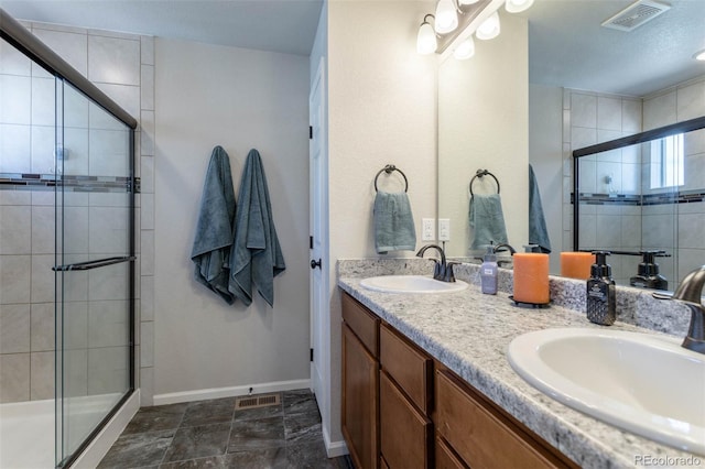 full bath featuring a shower stall, visible vents, and a sink