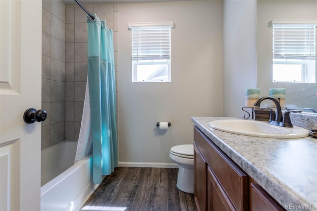 full bathroom featuring a healthy amount of sunlight, vanity, wood-type flooring, and toilet