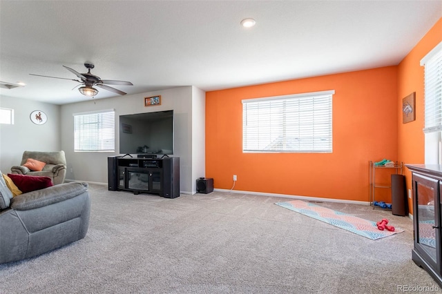 living area featuring light carpet, ceiling fan, visible vents, and baseboards