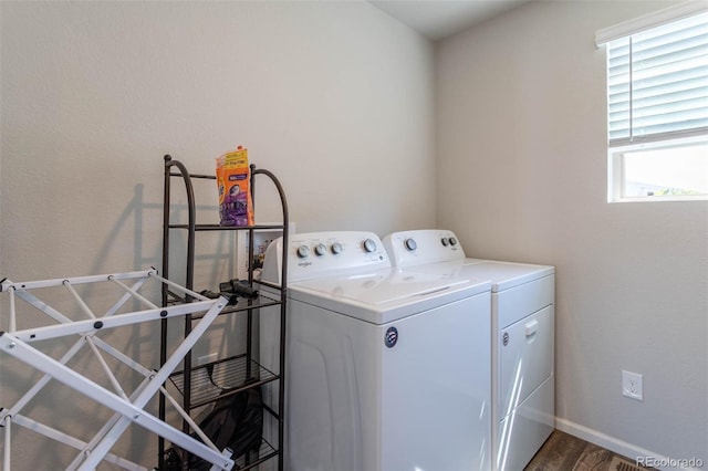 clothes washing area with dark wood-type flooring, laundry area, independent washer and dryer, and baseboards