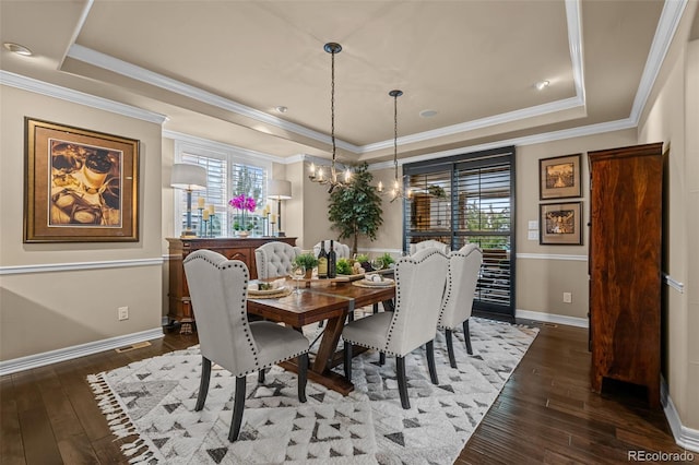 dining area featuring dark hardwood / wood-style floors, a tray ceiling, and a wealth of natural light