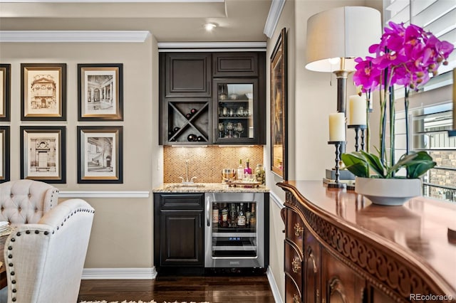 bar featuring wine cooler, dark wood-type flooring, dark brown cabinetry, light stone counters, and tasteful backsplash