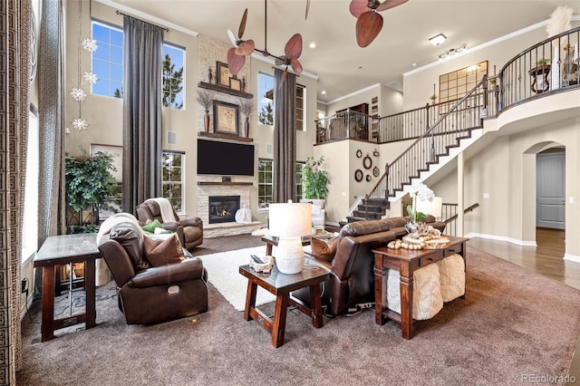 living room featuring crown molding, a fireplace, carpet floors, and a high ceiling