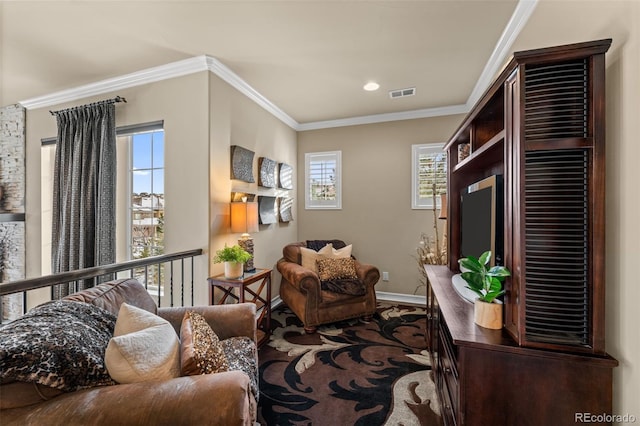 sitting room with ornamental molding and plenty of natural light