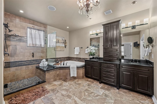 bathroom featuring plus walk in shower, vanity, and an inviting chandelier