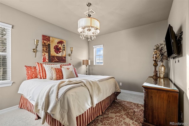 carpeted bedroom featuring an inviting chandelier